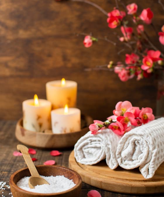 Ambiance relaxante avec serviettes, bougies et fleurs